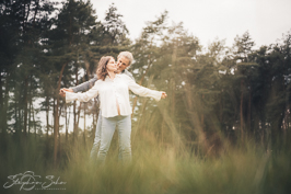 Päärchen mit Schwangerer Frau tanzend auf einer Wiese mit hohem Gras - Familienfotograf Brüggen Stephan Sohn